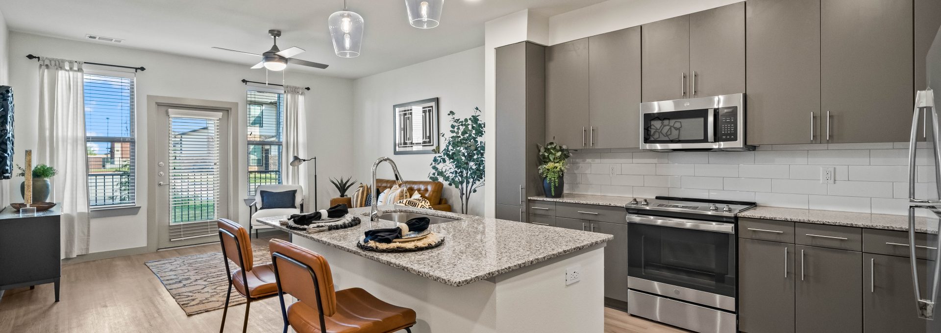 a kitchen with stainless steel appliances and hardwood floors at The La Ventana at Canyon West Apartments
